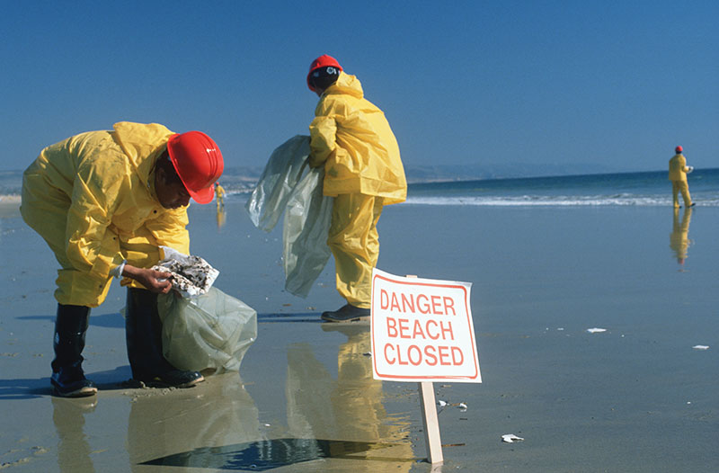 Hazardous material workers cleaning up the oil spill in Huntington Beach, Calif.